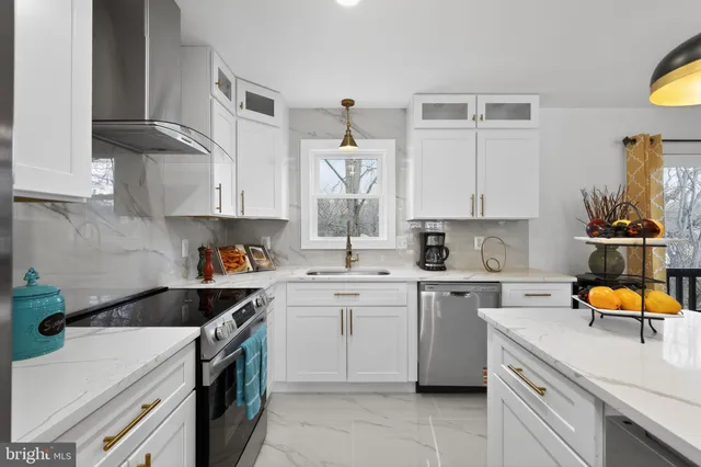 a kitchen with a sink dishwasher and white cabinets with wooden floor