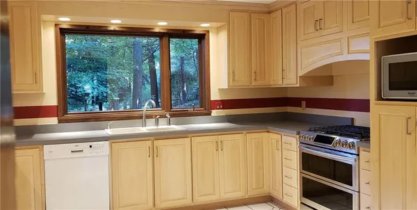 a kitchen with stainless steel appliances granite countertop a sink a stove and a microwave