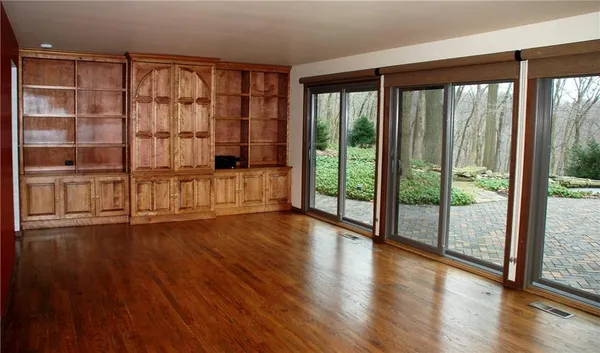 a view of empty room with wooden floor and floor to ceiling window