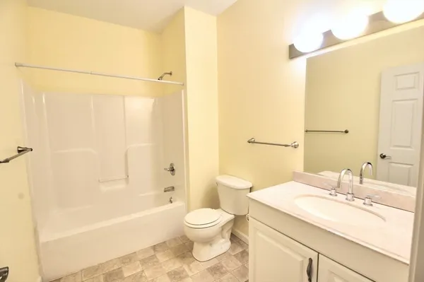 a bathroom with a granite countertop sink a toilet and shower