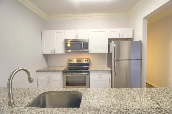 a kitchen with stainless steel appliances granite countertop a refrigerator sink and stove