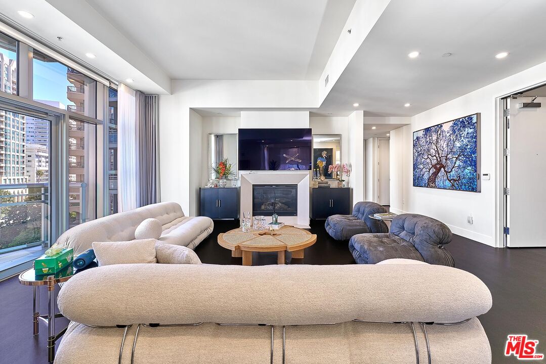 10776 Wilshire Boulevard, Unit 603 Los Angeles, CA 90024 - Photo 11 of 37 a living room with fireplace furniture and a flat screen tv