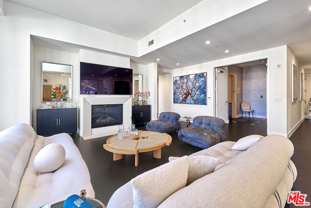 10776 Wilshire Boulevard, Unit 603 Los Angeles, CA 90024 - Photo 12 of 37 a living room with furniture a flat screen tv and a fireplace
