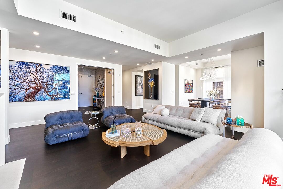 10776 Wilshire Boulevard, Unit 603 Los Angeles, CA 90024 - Photo 13 of 37 a living room with furniture and a large mirror