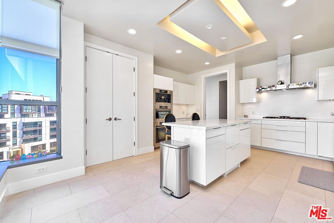 10776 Wilshire Boulevard, Unit 603 Los Angeles, CA 90024 - Photo 21 of 37 a kitchen with white cabinets and white appliances