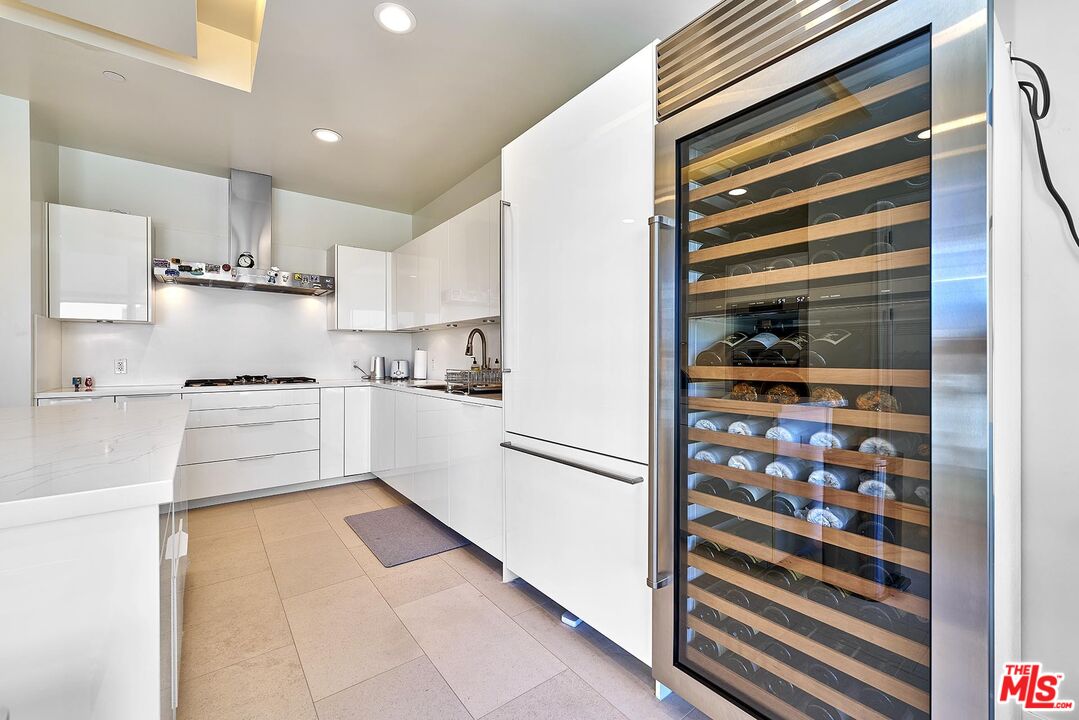 10776 Wilshire Boulevard, Unit 603 Los Angeles, CA 90024 - Photo 23 of 37 a kitchen with white cabinets and white appliances