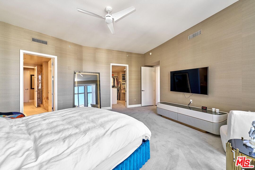 10776 Wilshire Boulevard, Unit 603 Los Angeles, CA 90024 - Photo 34 of 37 a spacious bedroom with a bed and a flat screen tv