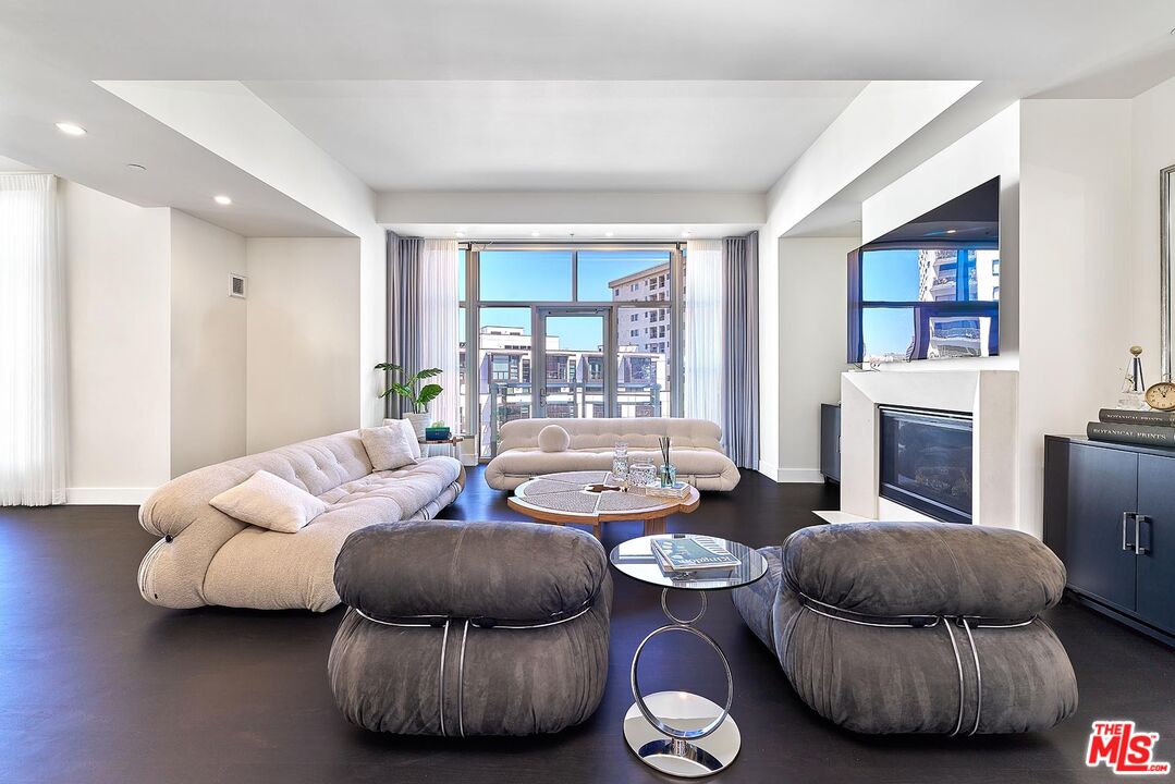 10776 Wilshire Boulevard, Unit 603 Los Angeles, CA 90024 - Photo 9 of 37 a living room with furniture and a fireplace