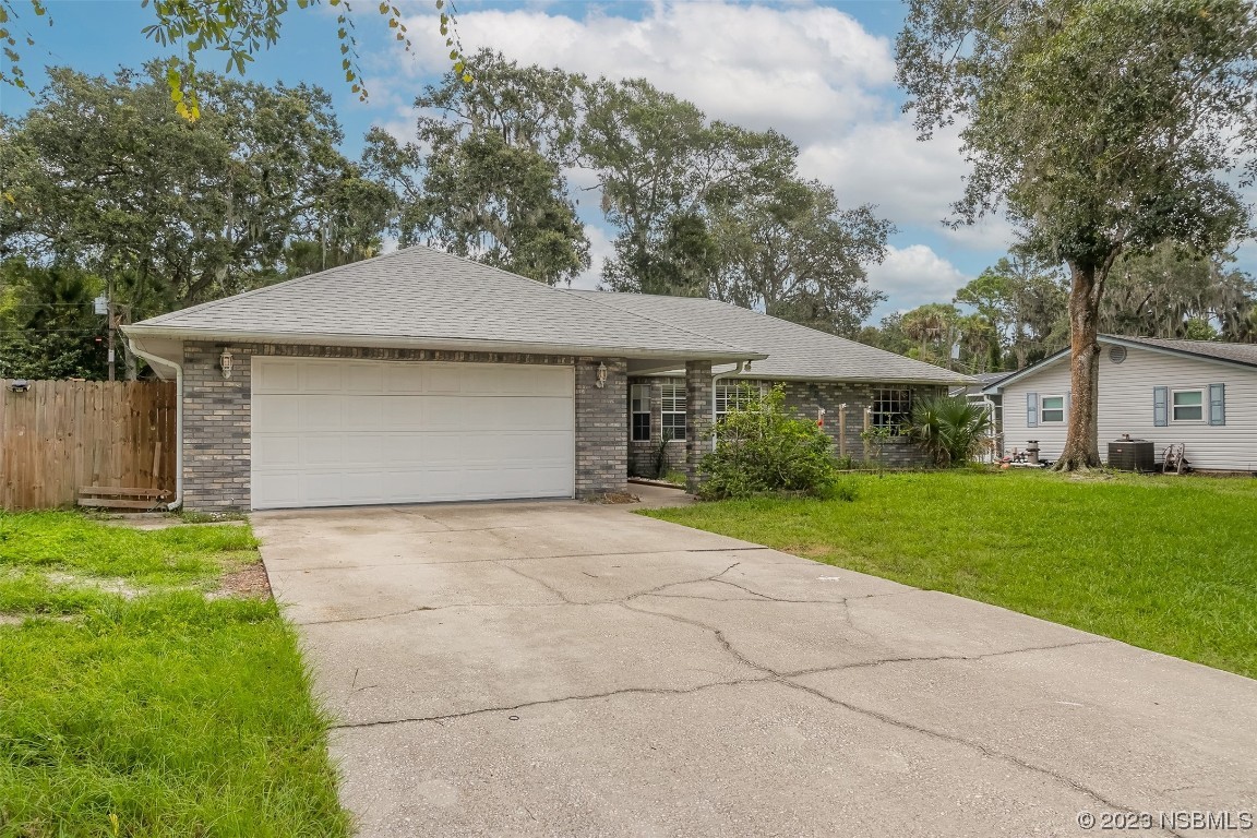 2311 Pine Tree Drive Edgewater, FL 32141 - Photo 1 of 32 a front view of a house with a yard and garage