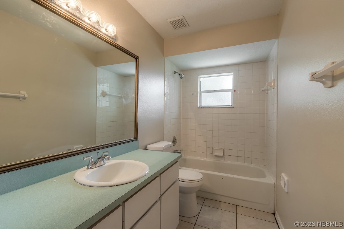 2311 Pine Tree Drive Edgewater, FL 32141 - Photo 13 of 32 a bathroom with a granite countertop sink toilet and shower