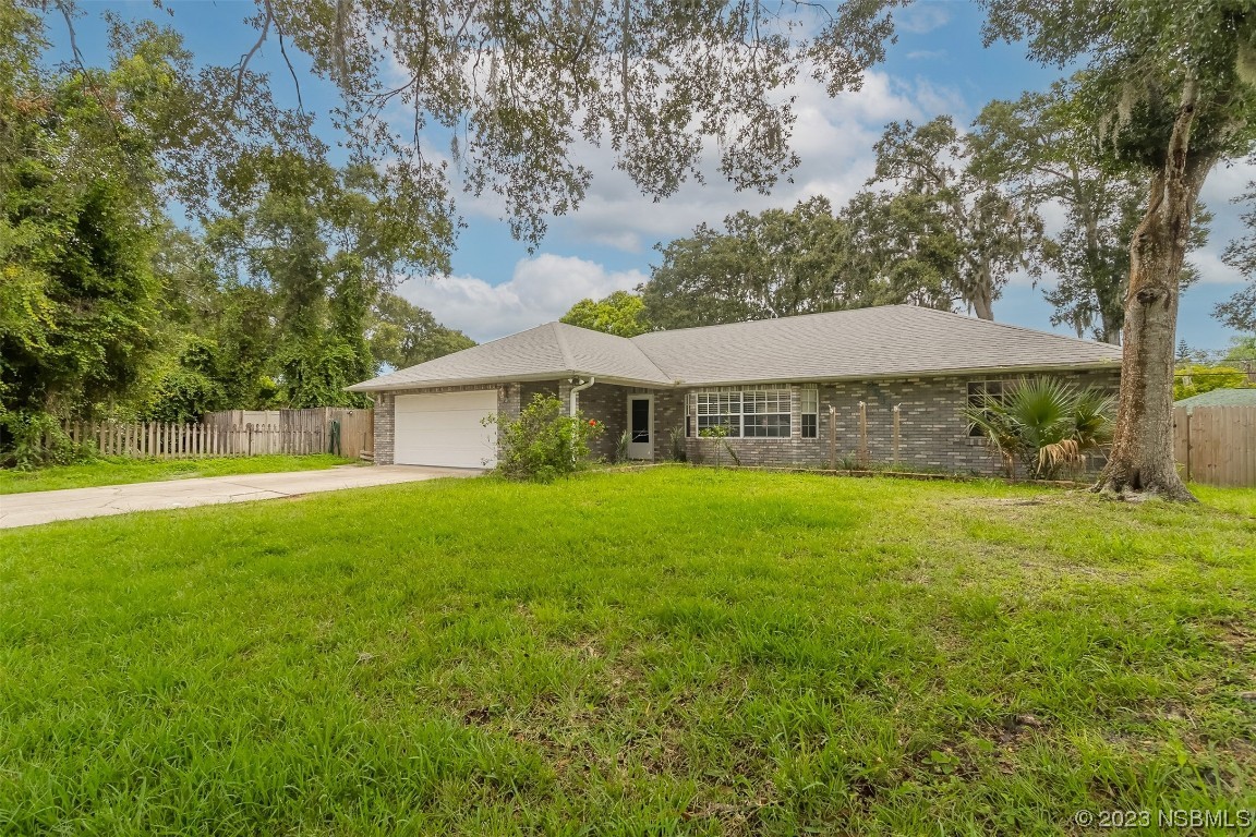 2311 Pine Tree Drive Edgewater, FL 32141 - Photo 3 of 32 a front view of a house with yard and green space