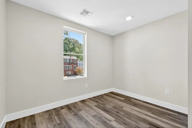 wooden floor in an empty room with a window