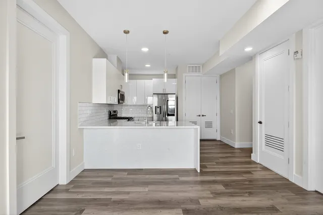 a view of kitchen with stainless steel appliances cabinets and wooden floor