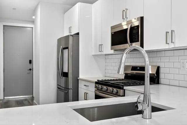 a kitchen with stainless steel appliances kitchen island a stove and a refrigerator