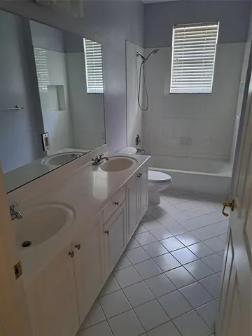 a bathroom with a granite countertop sink a toilet and shower