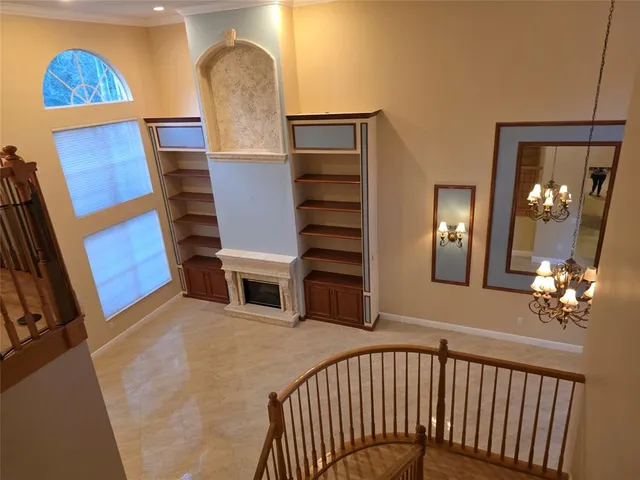 a view of a hallway with couches and chandelier