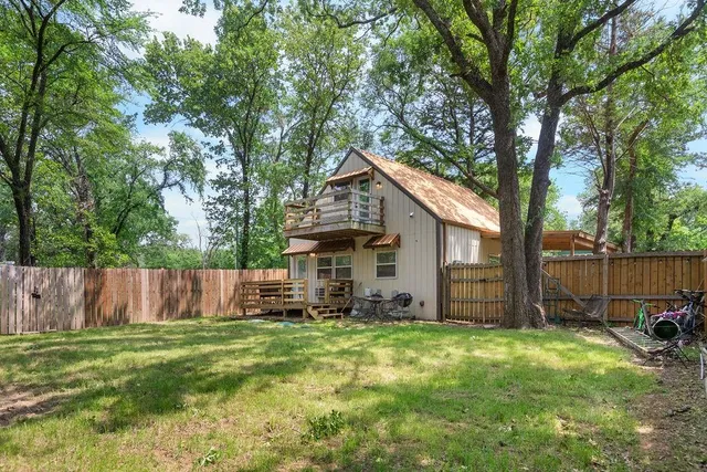a view of a house with a yard and large trees