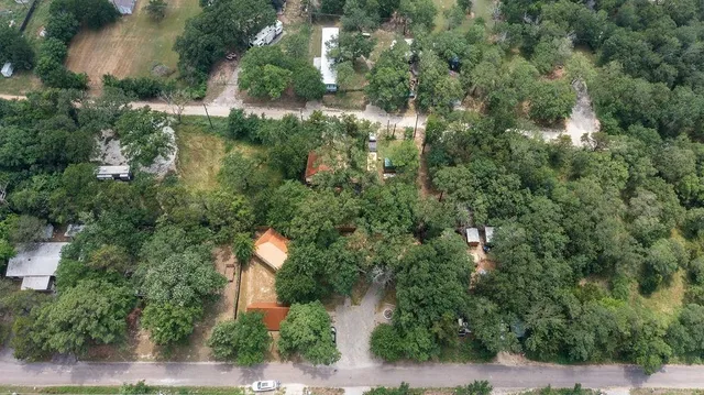 an aerial view of a house with a yard and trees