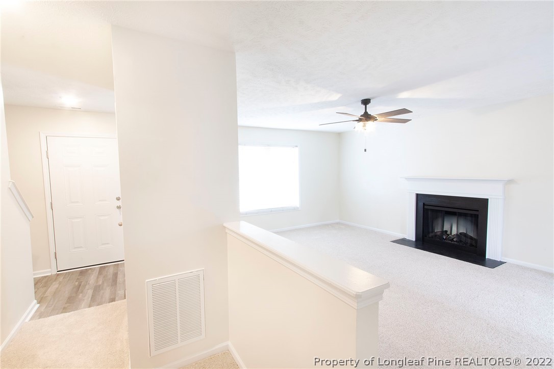 215 Cape Fear Road Raeford, NC 28376 - Photo 5 of 24 a living room with a fireplace furniture a ceiling fan and a window