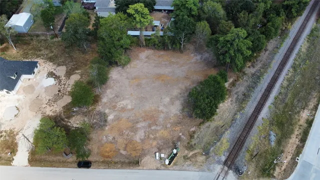 a view of a yard with plants and a bench