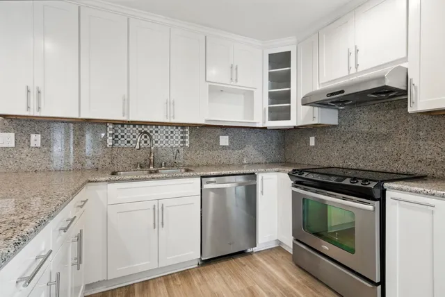 a kitchen with stainless steel appliances granite countertop a sink and a stove
