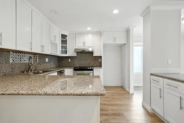a view of a kitchen with granite countertop stainless steel appliances