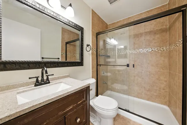 a bathroom with a sink a toilet and shower