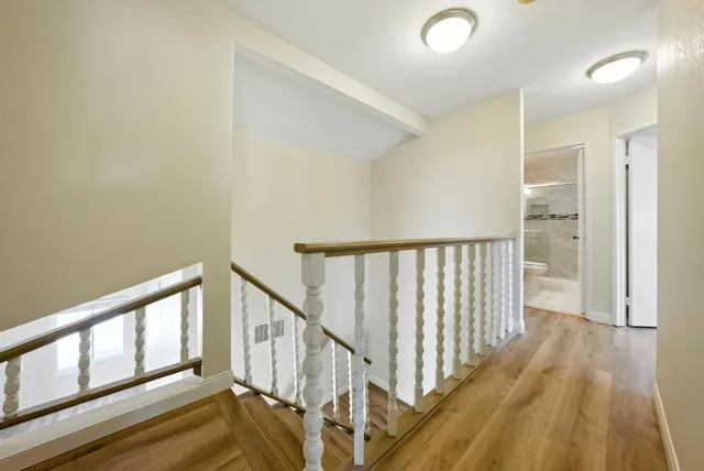 a view of a hallway with wooden floor and stairs
