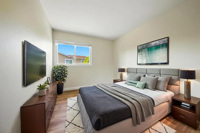 a bedroom with a bed and a flat screen tv