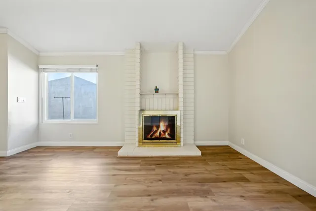 a view of an empty room with window and fire place