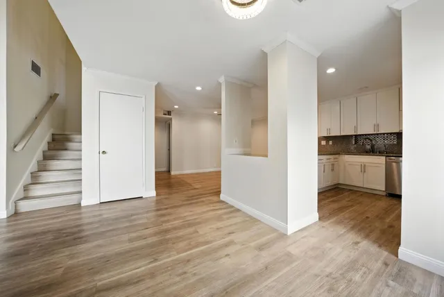 a view of a kitchen with wooden floor and electronic appliances