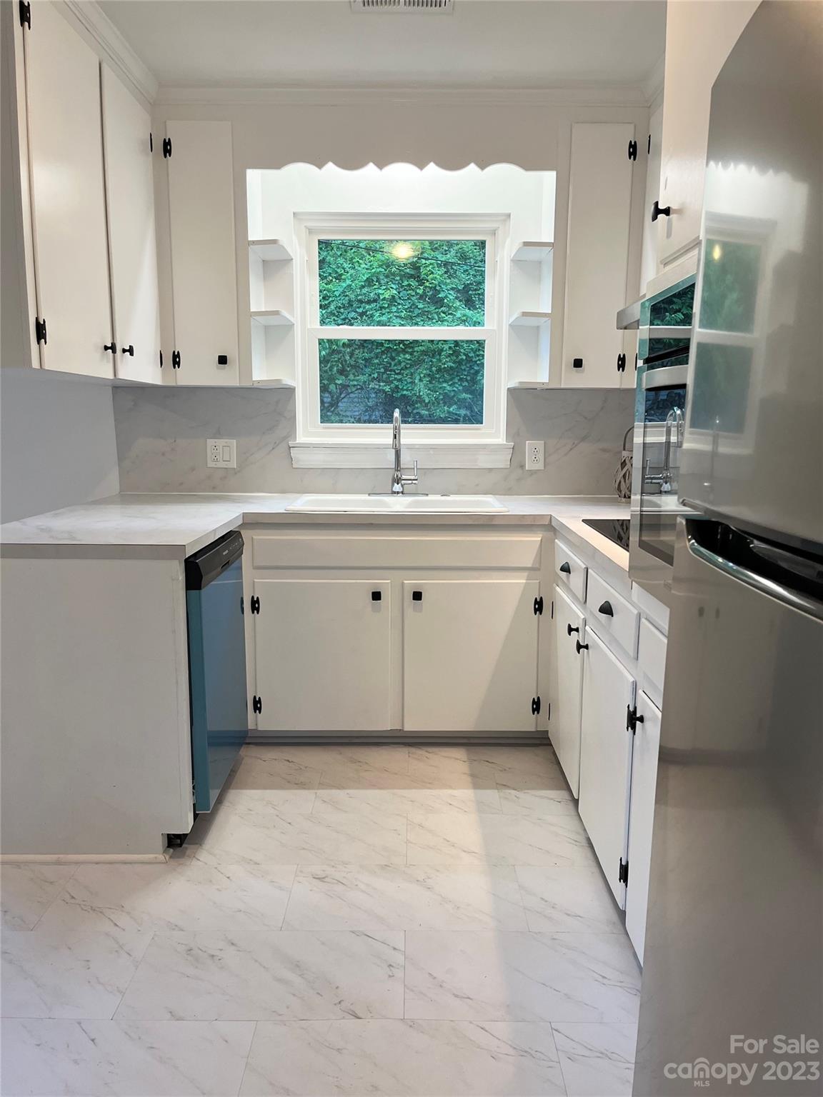 35 Circle Loop Stony Point, NC 28678 - Photo 20 of 46 a kitchen with white cabinets a sink a window and stainless steel appliances