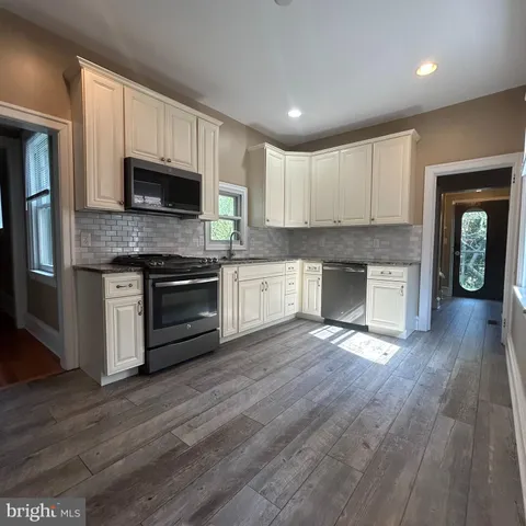 a kitchen with stainless steel appliances granite countertop a stove top oven a sink and a microwave