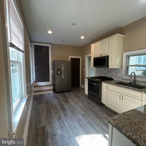 a kitchen with stainless steel appliances granite countertop a stove a sink and a refrigerator