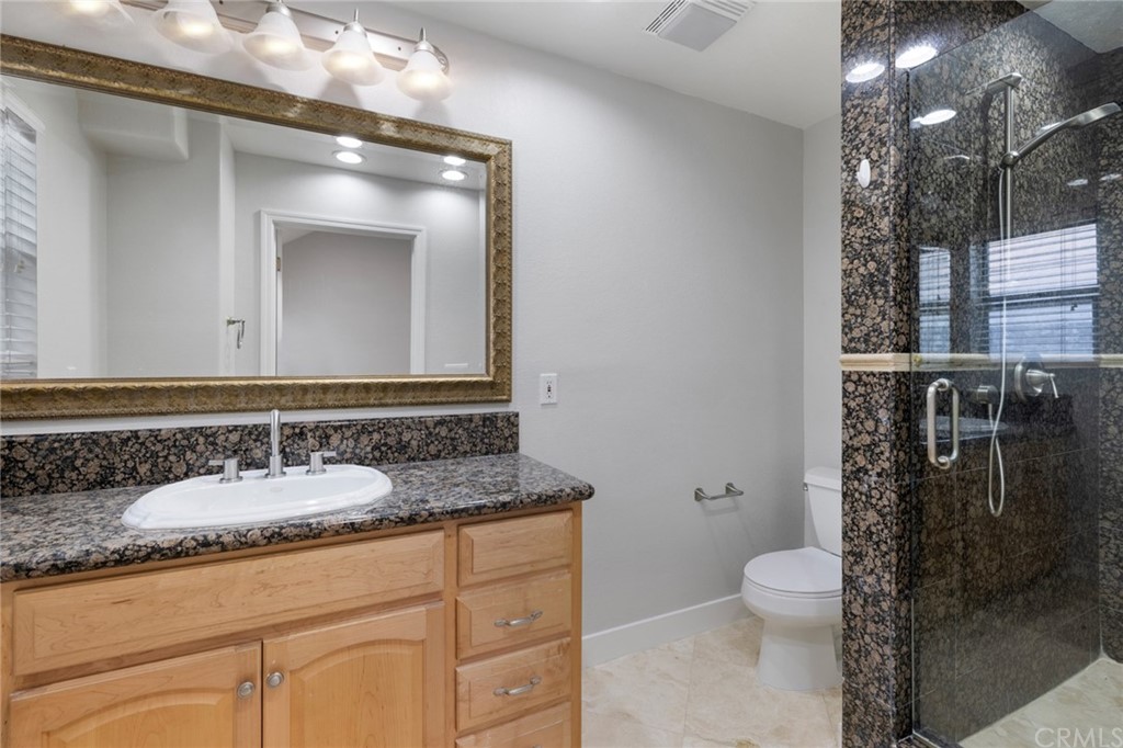33696 Bridgehampton Drive Dana Point, CA 92629 - Photo 17 of 20 a bathroom with a granite countertop sink a toilet and a mirror