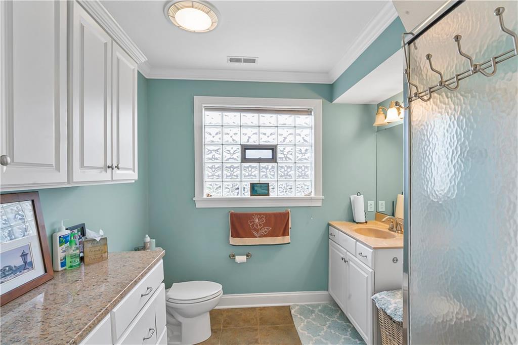 222 Arch Street, Unit E Verona, PA 15147 - Photo 17 of 24 a bathroom with a granite countertop sink a toilet and a shower