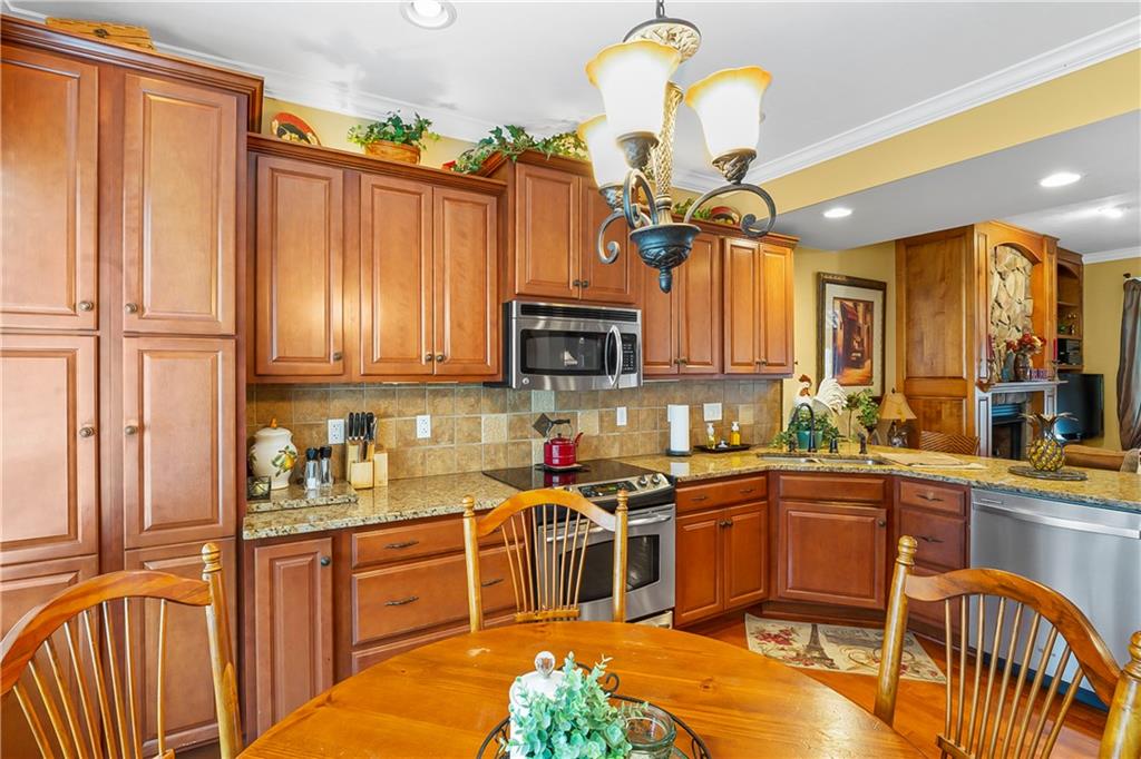 222 Arch Street, Unit E Verona, PA 15147 - Photo 6 of 24 a kitchen with stainless steel appliances granite countertop a stove top oven a sink dishwasher and cabinets with wooden floor