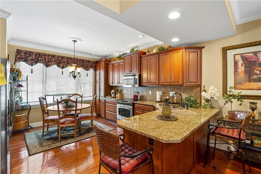 222 Arch Street, Unit E Verona, PA 15147 - Photo 7 of 24 a kitchen with sink refrigerator dining table and chairs