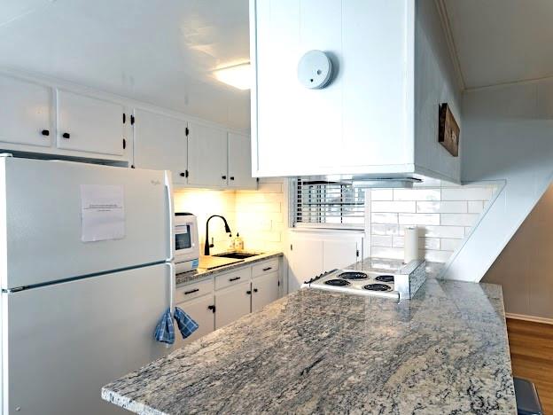 3817 Blue Fin Road Caddo, TX 76429 - Photo 15 of 40 a kitchen with granite countertop a refrigerator a stove a sink dishwasher and white countertops with wooden floor