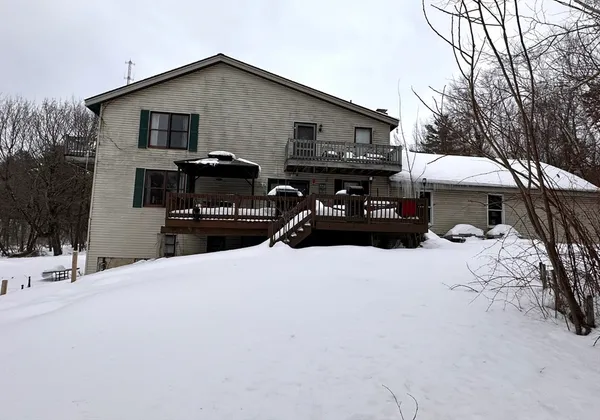 a front view of a house with a yard covered in snow