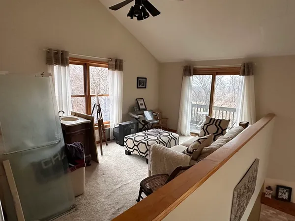 a living room with furniture floor to ceiling window and a flat screen tv