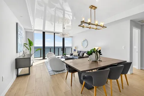a view of a dining room with furniture a chandelier and wooden floor
