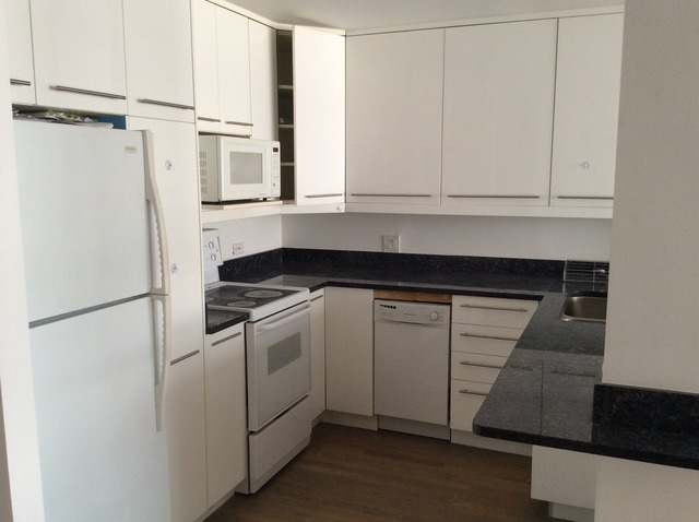 5415 North Sheridan Road, Unit 1002 Chicago, IL 60640 - Photo 4 of 11 a kitchen with white cabinets and white appliances