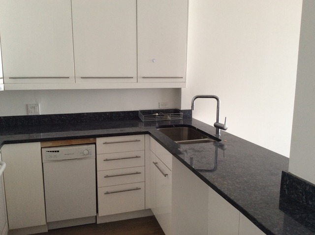 5415 North Sheridan Road, Unit 1002 Chicago, IL 60640 - Photo 5 of 11 a kitchen with granite countertop white cabinets and sink