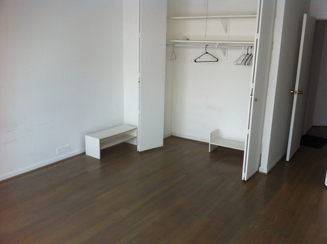 5415 North Sheridan Road, Unit 1002 Chicago, IL 60640 - Photo 9 of 11 an empty room with wooden floor and closet