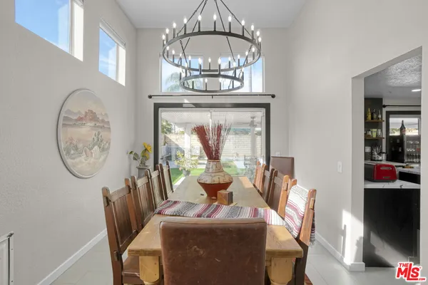 a view of a dining room with furniture a chandelier and wooden floor