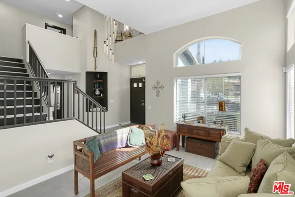 a living room with furniture fireplace and a large window