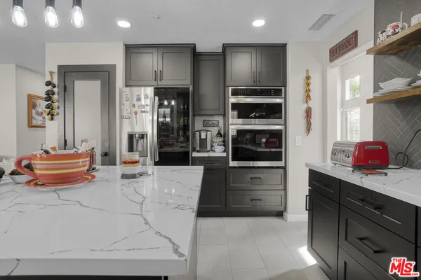 a kitchen with stainless steel appliances kitchen island granite countertop a refrigerator and stove