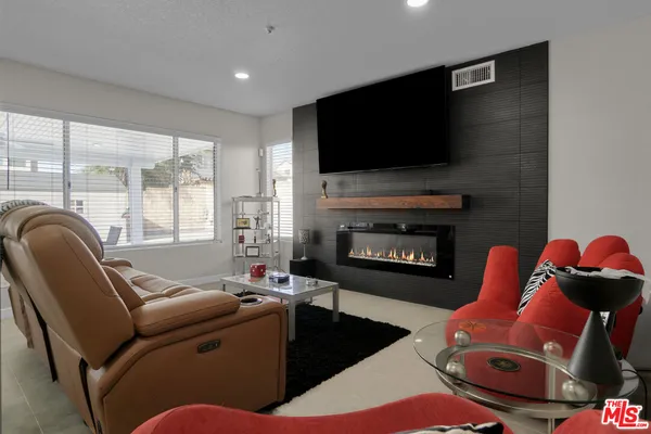 a living room with furniture a flat screen tv and a fireplace