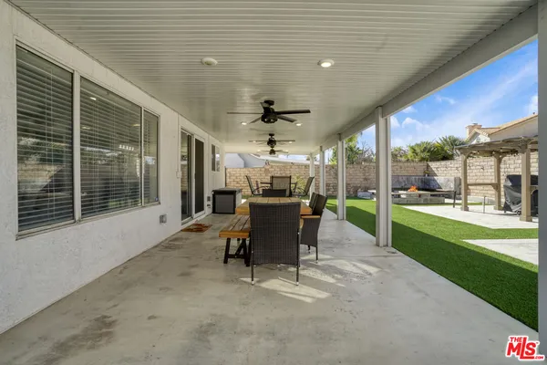 a view of a patio with table and chairs potted plants with wooden floor and fence